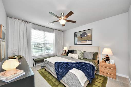 A bedroom with a bed, nightstand, and a ceiling fan.