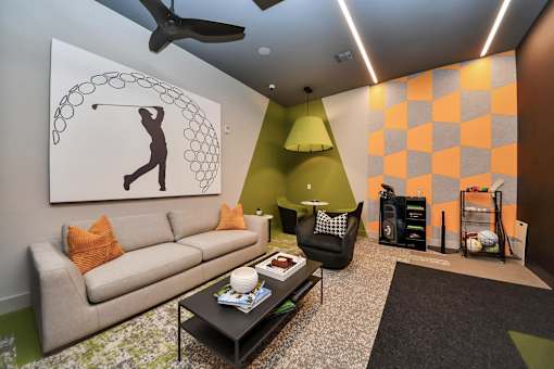 A living room with a couch, a coffee table, and a painting of a person playing golf.