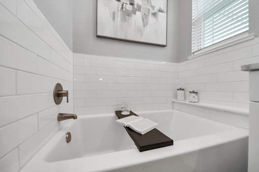 A white bathtub with a book on top of it.