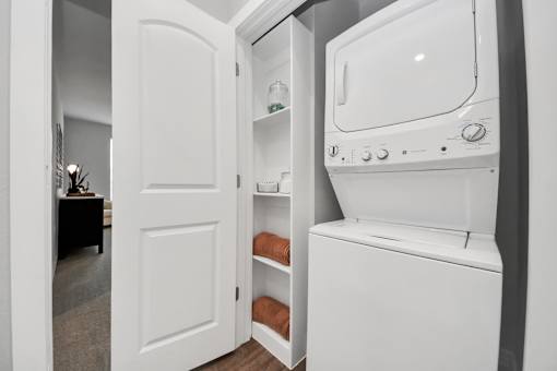 A white stackable washer and dryer in utility room