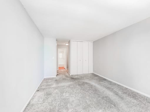a bedroom with grey carpet and white walls