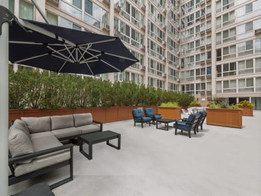 an outdoor lounge area with couches chairs and umbrellas
