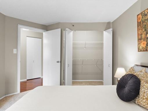 A bedroom with a bed, pillows, and a painting on the wall.