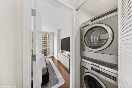 a laundry room with a washer and dryer and a door to a hallway