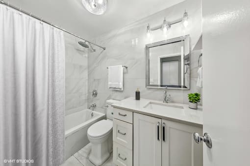 a white bathroom with a shower toilet and sink