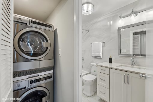a bathroom with a washing machine and a toilet and a sink