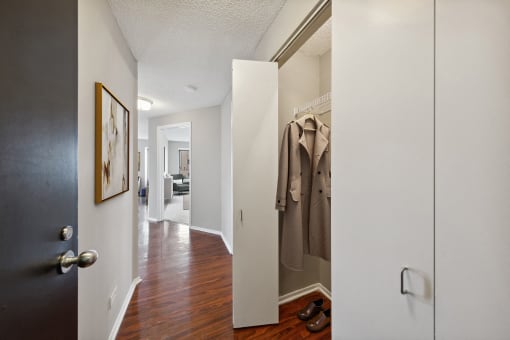 a hallway with a door to a closet with a jacket hanging on it