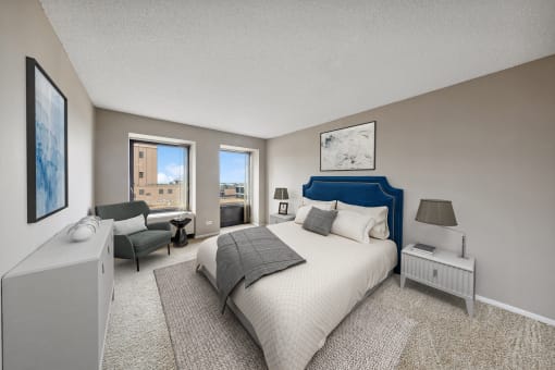 a master bedroom with a bed and a chair and a window