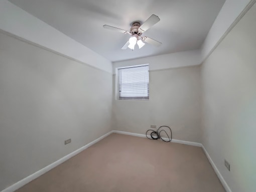 a bedroom with a ceiling fan and a window