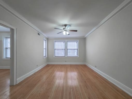 a bedroom with hardwood floors and a ceiling fan