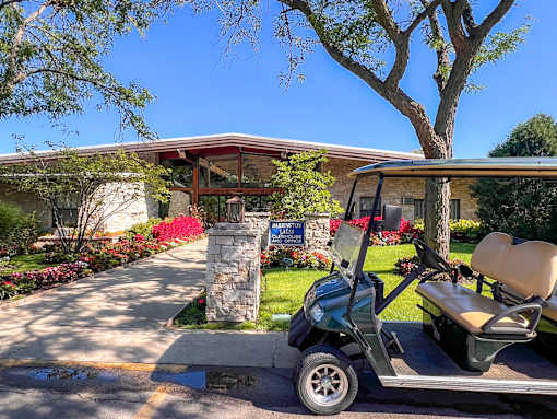 A golf cart is parked in front of a house with a sign that says "Welcome to Paradise.".