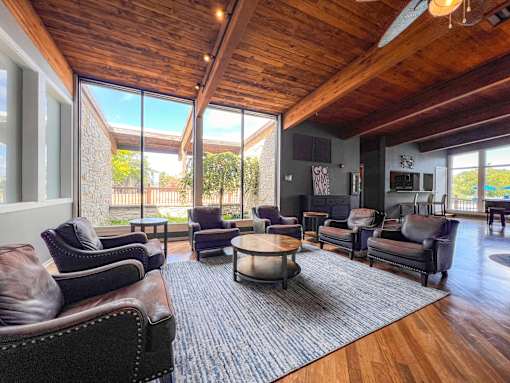 A living room with brown leather chairs and a wooden ceiling.