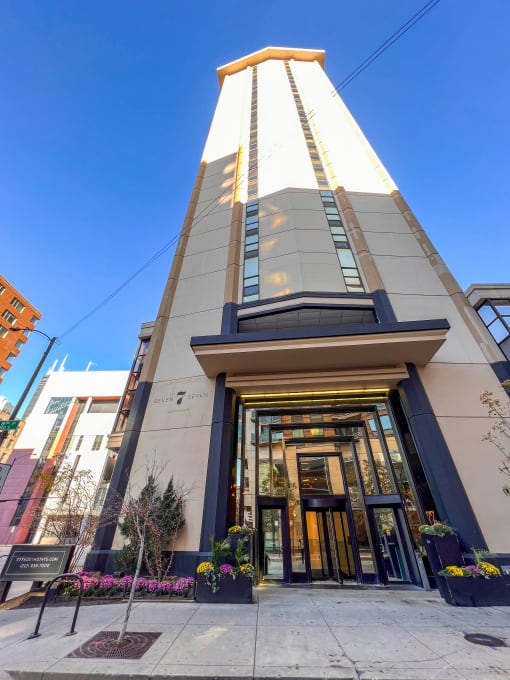 a view of the front of a tall building with a blue sky