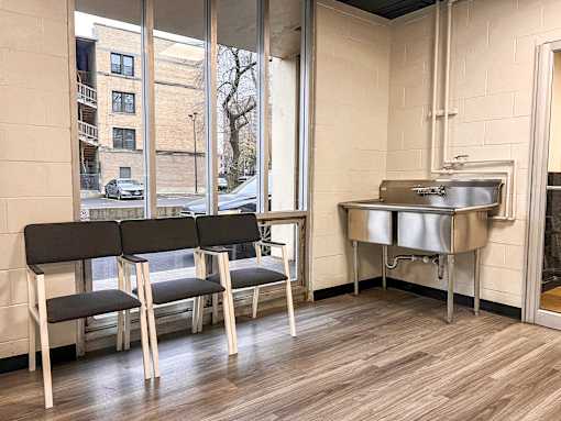 A room with a table, chairs and a sink.