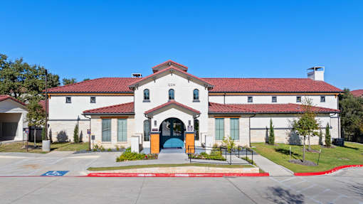 a white building with a blue door and a red roof