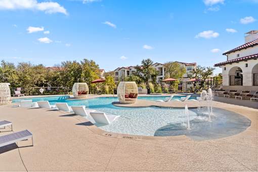 a swimming pool with chairs and a water fountain