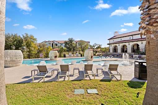a swimming pool with lounge chairs and a water fountain