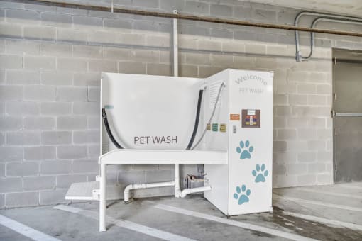 a pet wash machine in front of a brick wall