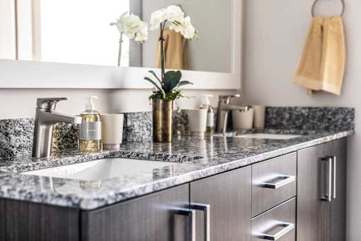 A bathroom with a marble countertop and a large mirror.