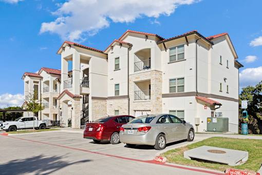 two cars parked in front of an apartment building