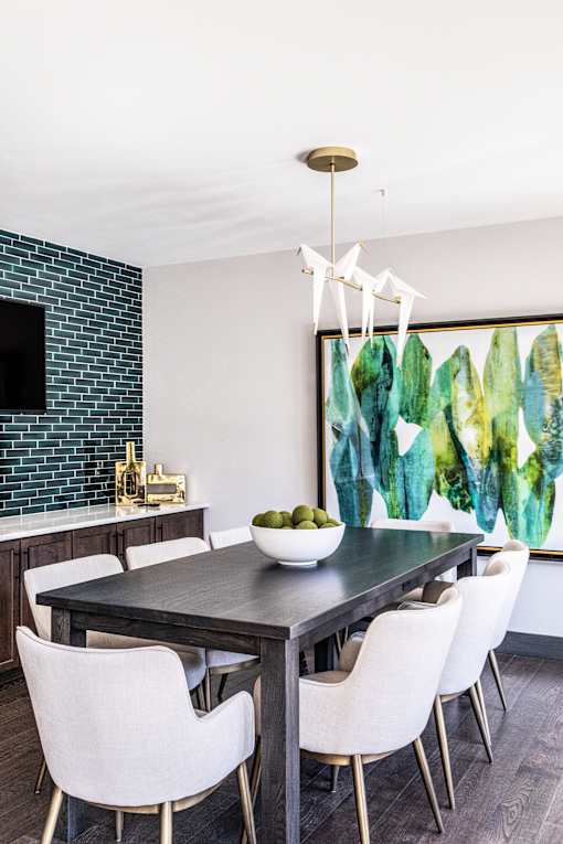 A modern dining room with a black table and white chairs.