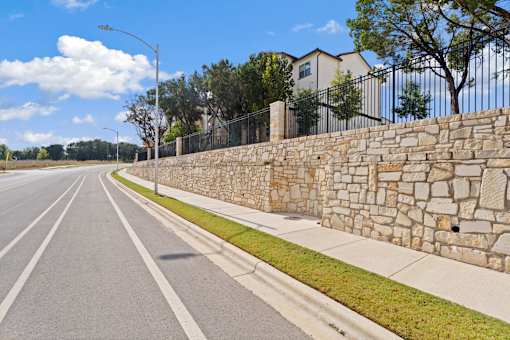 a stone retaining wall on the side of a road