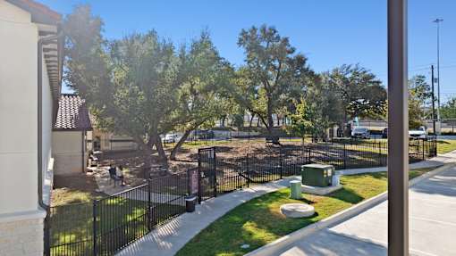 a view of a yard with a fenced in area and trees
