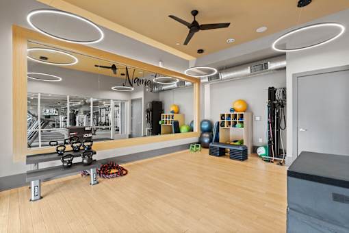 a gym with a large mirror and a work out area with weights and other equipment