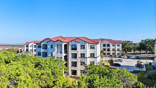an aerial view of an apartment building with a parking lot