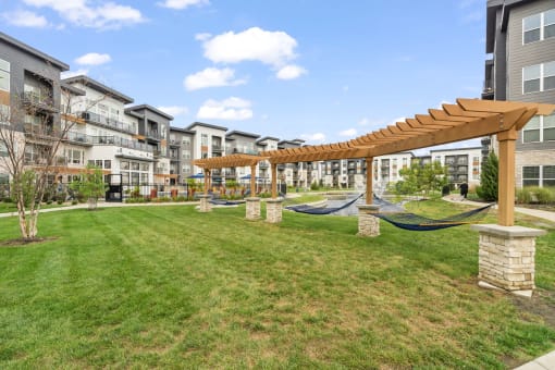 a grassy area with hammocks in the middle of an apartment building
