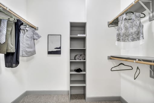 a walk in closet with wooden shelves and rails and a mirror hanging on the wall