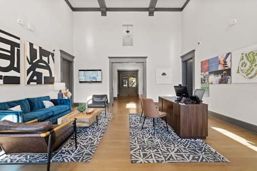 a living room with a blue couch and a desk