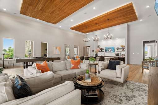 A modern living room with a wooden ceiling and a large sectional sofa.