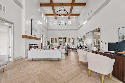 A modern living room with a white sofa and a wooden floor.