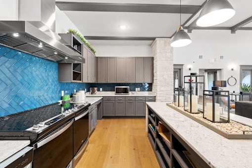 a large kitchen with marble counter tops and blue tile