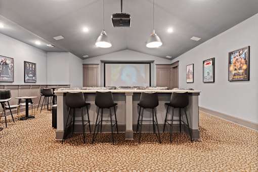 a large table with chairs in a room with a projector screen