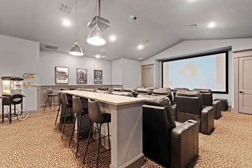 a meeting room with a bar and chairs and a projector screen