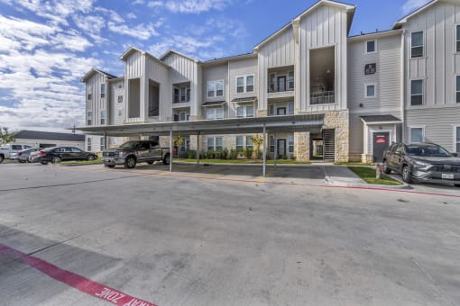 an empty parking lot in front of an apartment building