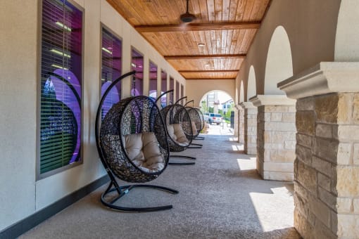 a row of hanging chairs outside of a building