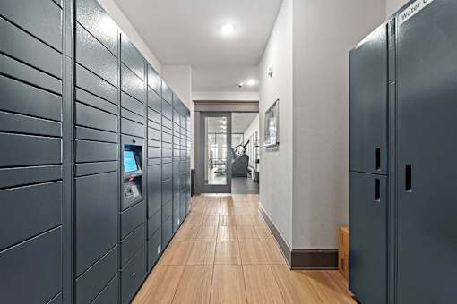 a long hallway with blue lockers and wood floors