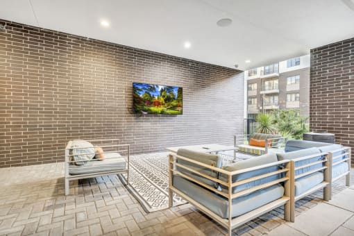 a living room with a brick wall and a flat screen tv on the wall