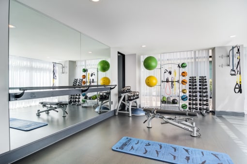 a workout room with weights and other equipment in a large room with mirrors