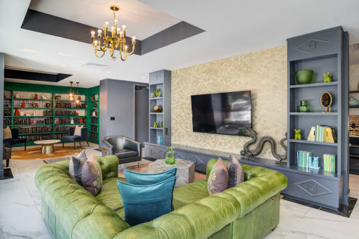 a living room with a green couch and a television