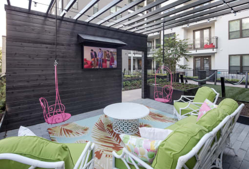 a patio with tables and chairs and a tv on the wall
