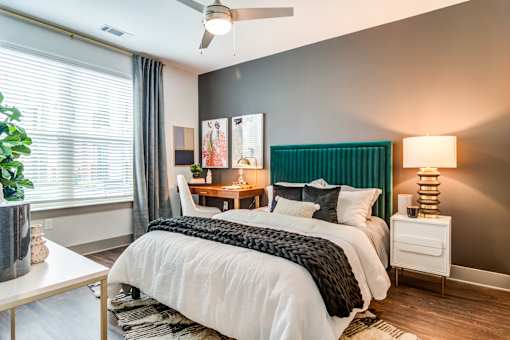 A bedroom with a white bed and a green headboard.