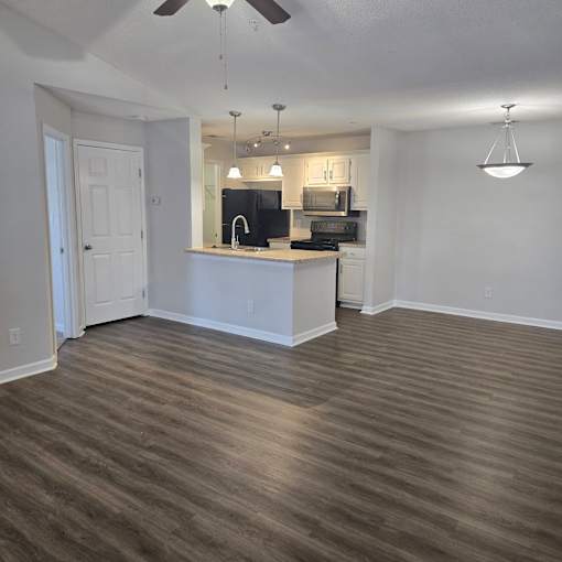 A kitchen with a white counter and a black stove top oven.