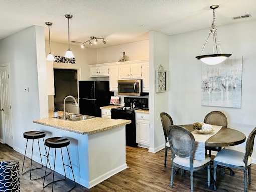 A kitchen with a bar and a dining table.
