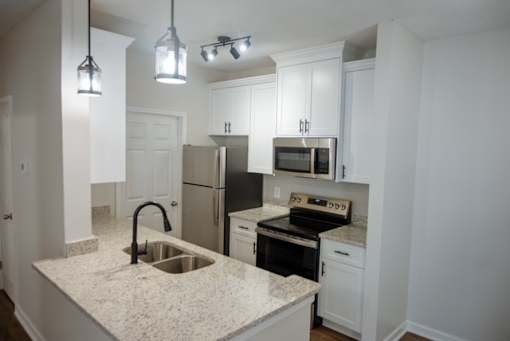 A kitchen with granite countertops and stainless steel appliances.