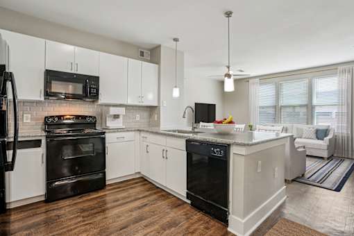 A modern kitchen with white cabinets and black appliances at Highline Urban Lofts Apartments, Cypress, Texas