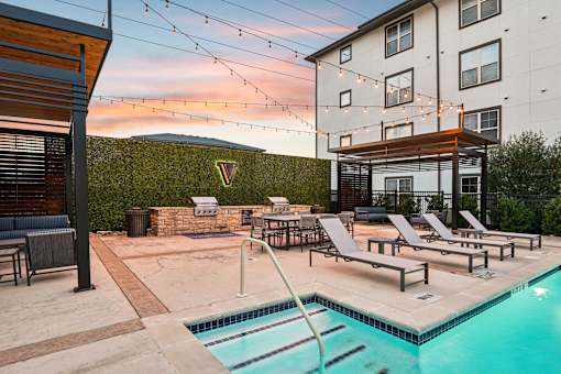 pool with a slide and sun loungers at Vine + Vail Townhomes and Apartments, Grapevine